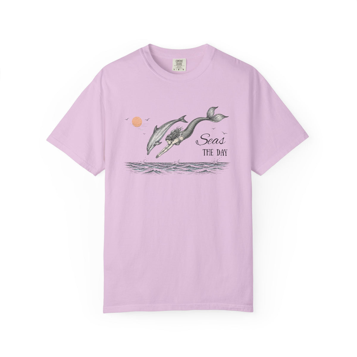 A light purple short-sleeve crewneck t-shirt featuring a graphic print of two dolphins jumping over water with the text 'Seas THE DAY' and a small orange sun.