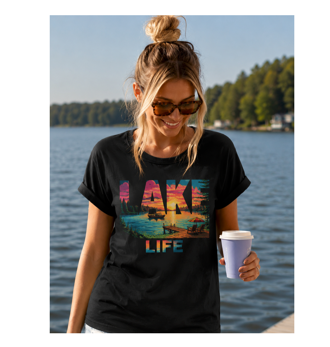 Woman wearing a black t-shirt with 'Lake Life' design by a lake.