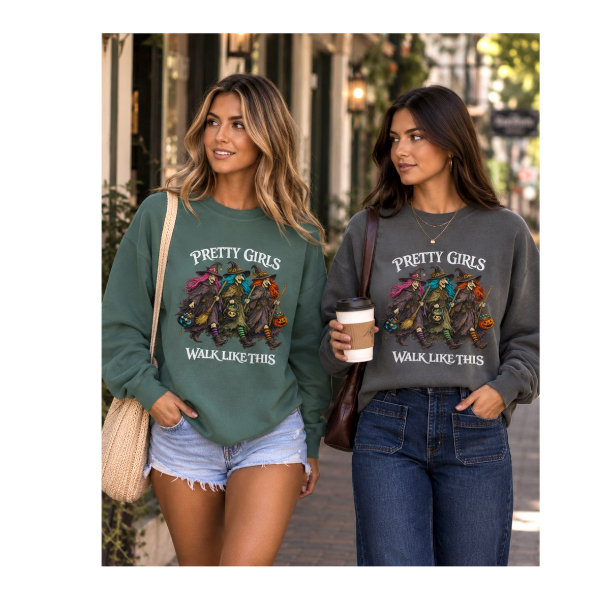Two women walking outdoors on a city street wearing matching graphic sweatshirts. The sweatshirt on the left is sage green with a colorful illustration and the text 'PRETTY GIRLS WALK LIKE THIS,' and the sweatshirt on the right is charcoal gray with the same graphic and text.